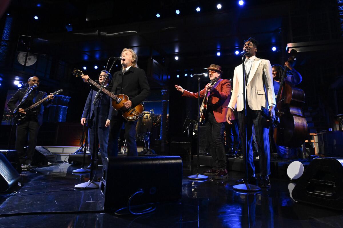 A group of men perform a song on stage.