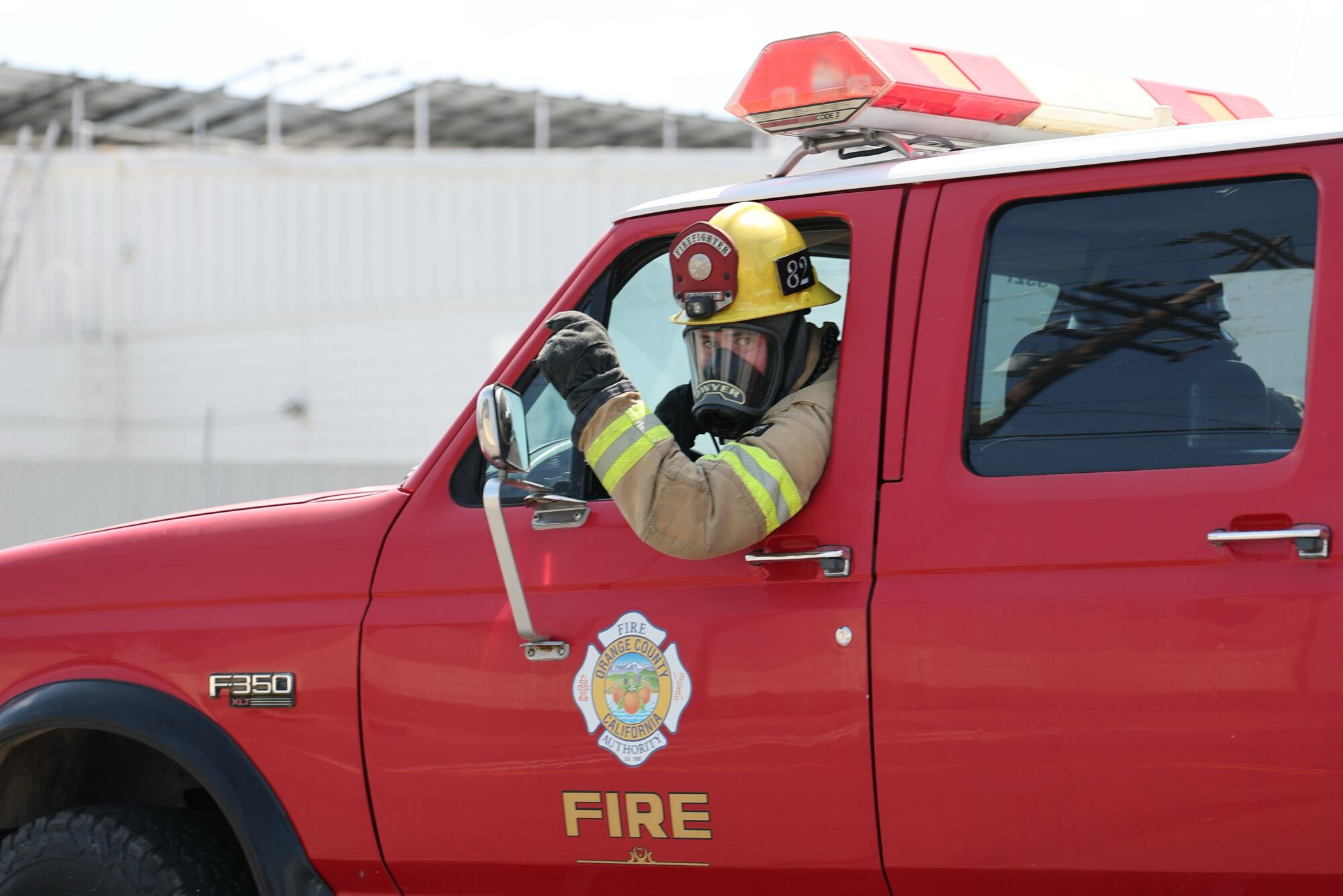 An Orange County Fire Department firefighter instructs a photographer to evacuate.