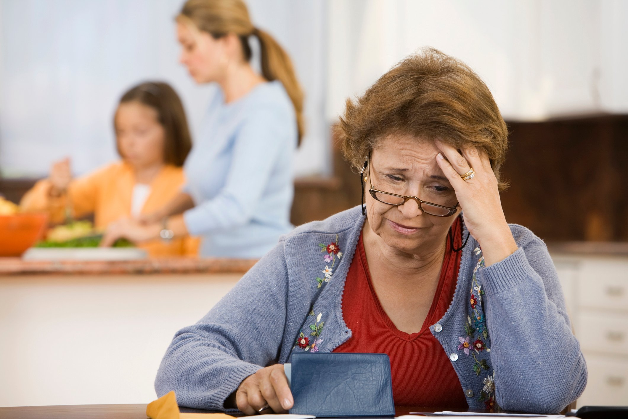 A person looks worried while holding a checkbook.