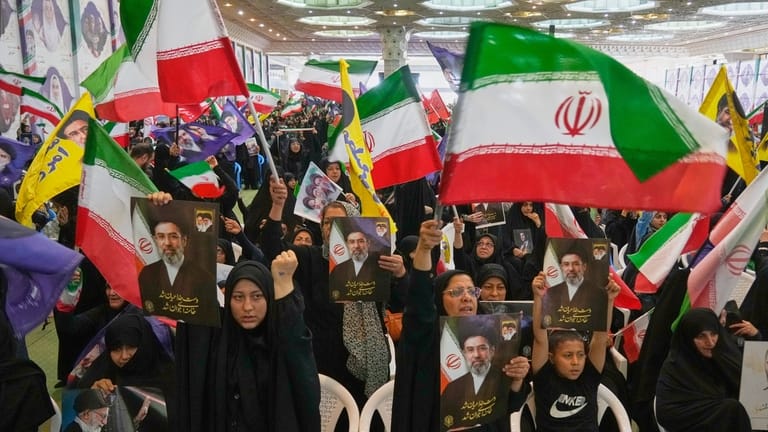 Government supporters hold Iranian flags and pictures of Iran's Supreme...