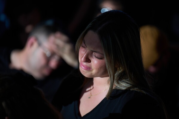 Adi, sister of Israeli soldier Staff sergeant Noam Hamburger, who was killed in a Lebanese drone attack on northern Israel, mourns over his casket during his funeral in Atlit, Israel, Sunday, May 24, 2026. (AP Photo/Ariel Schalit)
