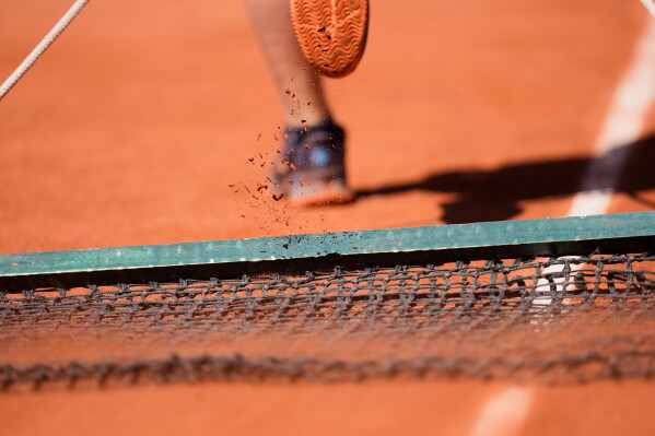 A stadium worker cleans the lines during the first round women's singles tennis match between Aryna Sabalenka of Belarus and Jessica Bouzas Maneiro of Spain at the French Open tennis tournament in Paris, Tuesday, May 26, 2026. (AP Photo/Christophe Ena)