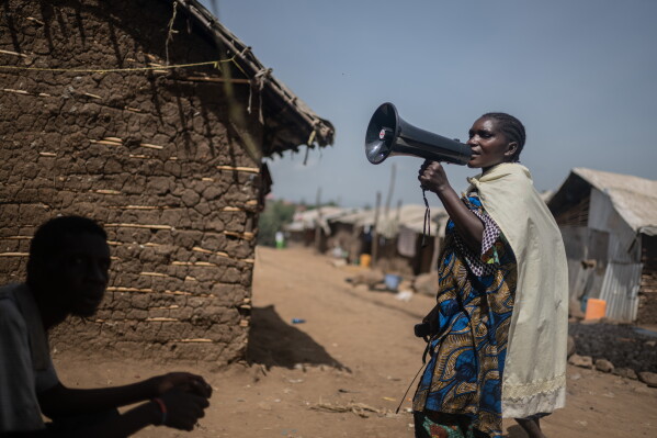 Machozi Naumi, 45, raises awareness of Ebola in the camp on the property of the city's ISP (Institut Supérieur Pédagogique), where internally displaced people reside in Bunia, Congo, Tuesday, May 26, 2026. (AP Photo/Moses Sawasawa)