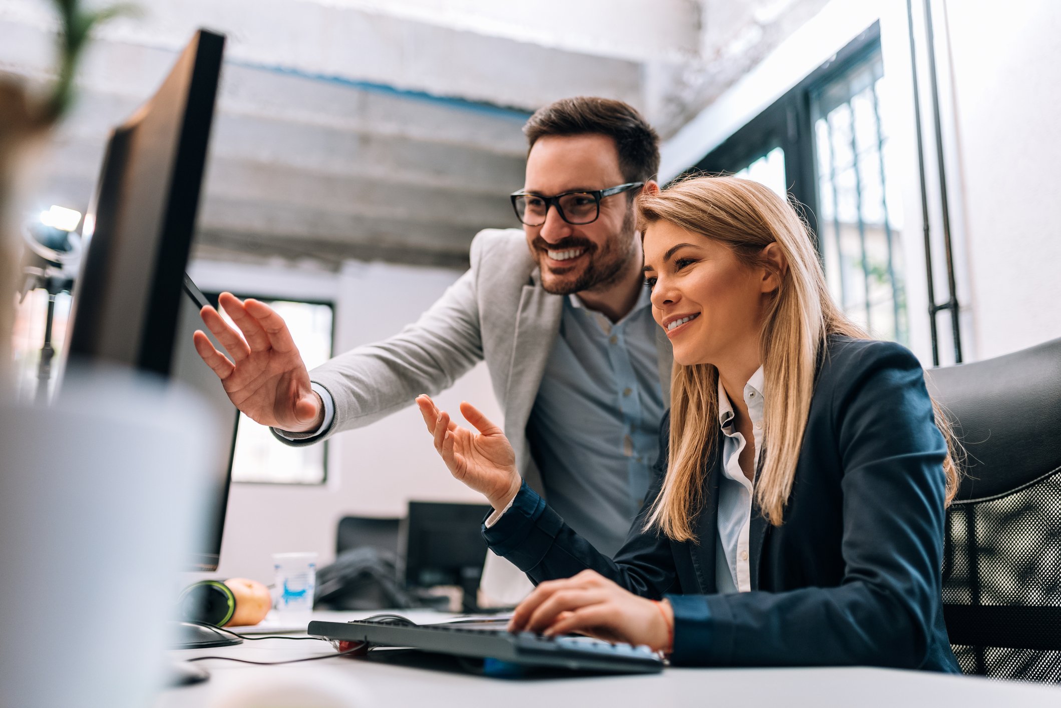 Two investors look at something on a computer.
