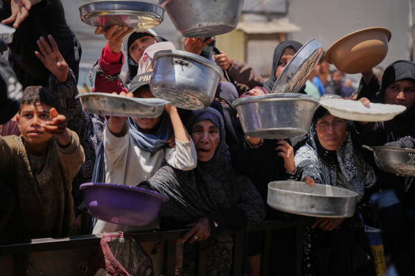Palestinians wait to receive donated food at a distribution center in Khan Younis, Gaza Strip, Wednesday, May 27, 2026. (AP Photo/Abdel Kareem Hana)