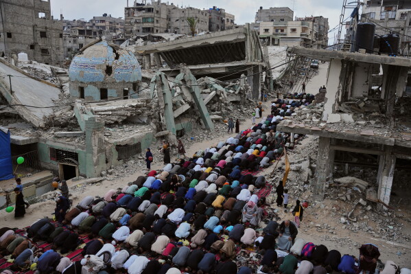 Palestinians offer Eid al-Adha prayers beside the ruins of a mosque destroyed by Israeli bombardment, in Khan Younis, southern Gaza Strip, Wednesday, May 27, 2026. (AP Photo/Abdel Kareem Hana)
