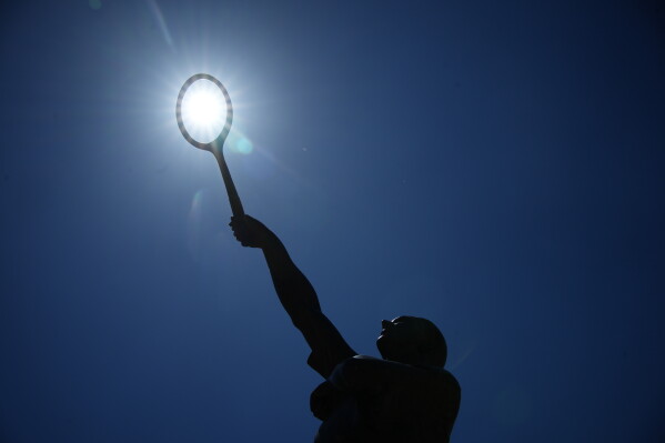 The sun shines over the statue of French tennis legend Jean Borotra at the French Open tennis tournament in Paris, Wednesday, May 27, 2026. (AP Photo/Christophe Ena)