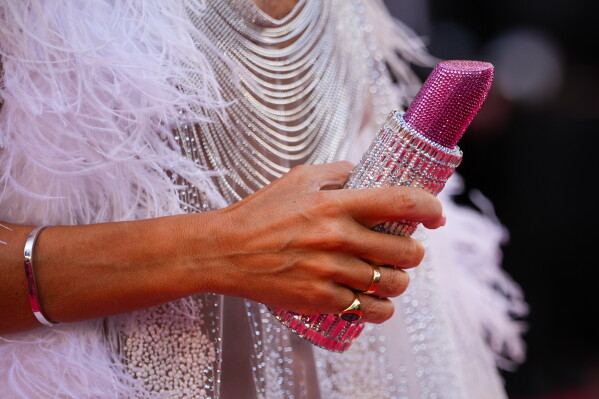 Lady Victoria Hervey holds a lipstick shaped purse upon arrival at the premiere of the film 'A Woman's Life' at the 79th international film festival, Cannes, southern France, Wednesday, May 13, 2026. (AP Photo/Andreea Alexandru)