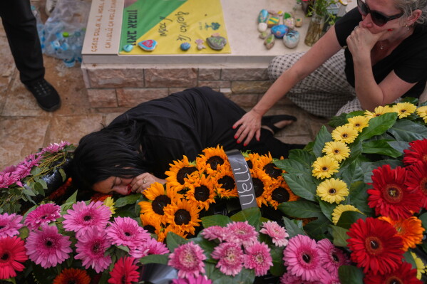 Hilit mourns over the grave of her daughter, Israeli soldier Sgt. Rotem Yanai, who was killed in a Lebanese drone attack in northern Israel, during her funeral in Givat Ada, Israel, Thursday, May 28, 2026. (AP Photo/Ariel Schalit)