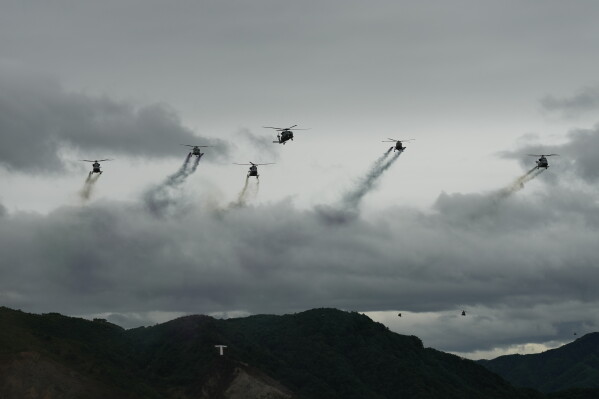 South Korean military helicopters fly in formation during a media day for a joint live fire exercise at the Seungjin training ground in Pocheon, South Korea, Thursday, May 21, 2026. (AP Photo/Lee Jin-man)