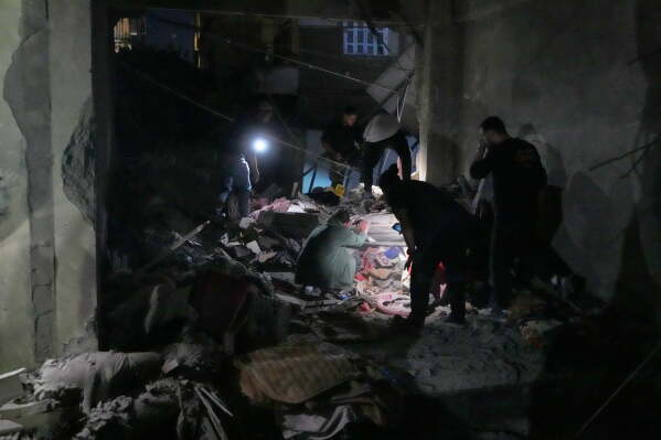 Rescue workers search for victims inside a destroyed apartment that was damaged by an Israeli airstrike in the southern port city of Sidon, Lebanon, Thursday, May 28, 2026. (AP Photo/Mohammed Zaatari)