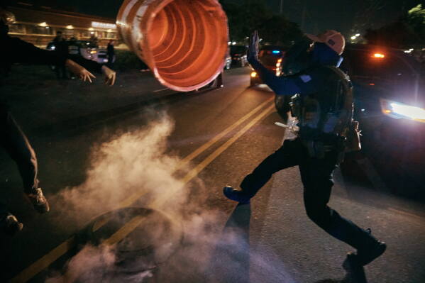 A protester throws a traffic cone to an ICE agent outside the Delaney Hall detention center during a protest on Wednesday, May 27, 2026, in Newark, N.J. (AP Photo/Andres Kudacki)