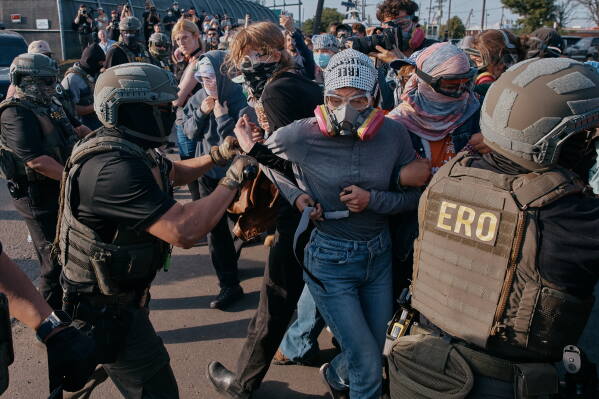 Protesters confront ICE agents outside the Delaney Hall detention center while demonstrating near the entrance gates, Wednesday, May 27, 2026, in Newark, N.J. (AP Photo/Andres Kudacki)