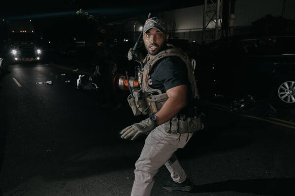 An ICE agent chases with protesters outside the Delaney Hall detention center during a protest on Wednesday, May 27, 2026, in Newark, N.J. (AP Photo/Andres Kudacki)