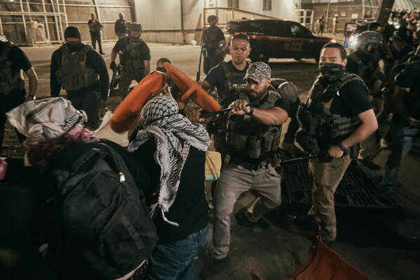 Protesters clash with ICE agents outside the Delaney Hall detention center while demonstrating near the entrance gates, Wednesday, May 27, 2026, in Newark, N.J. Inside the facility, detainees carried out a labor and hunger strike for days over alleged living conditions. (AP Photo/Andres Kudacki)