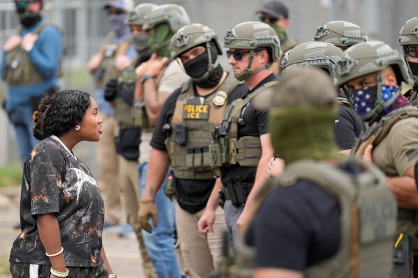 A protester talks to masked federal agents standing outside the Delaney Hall detention center during a protest against the transfer of detainees on Wednesday, May 27, 2026, in Newark, N.J. (AP Photo/Seth Wenig)