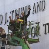 Workers react to the media after updating signage outside the Kennedy Center on Dec. 19, 2025, in Washington, D.C.