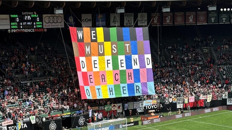 Fans display a banner at an NWSL soccer match between...