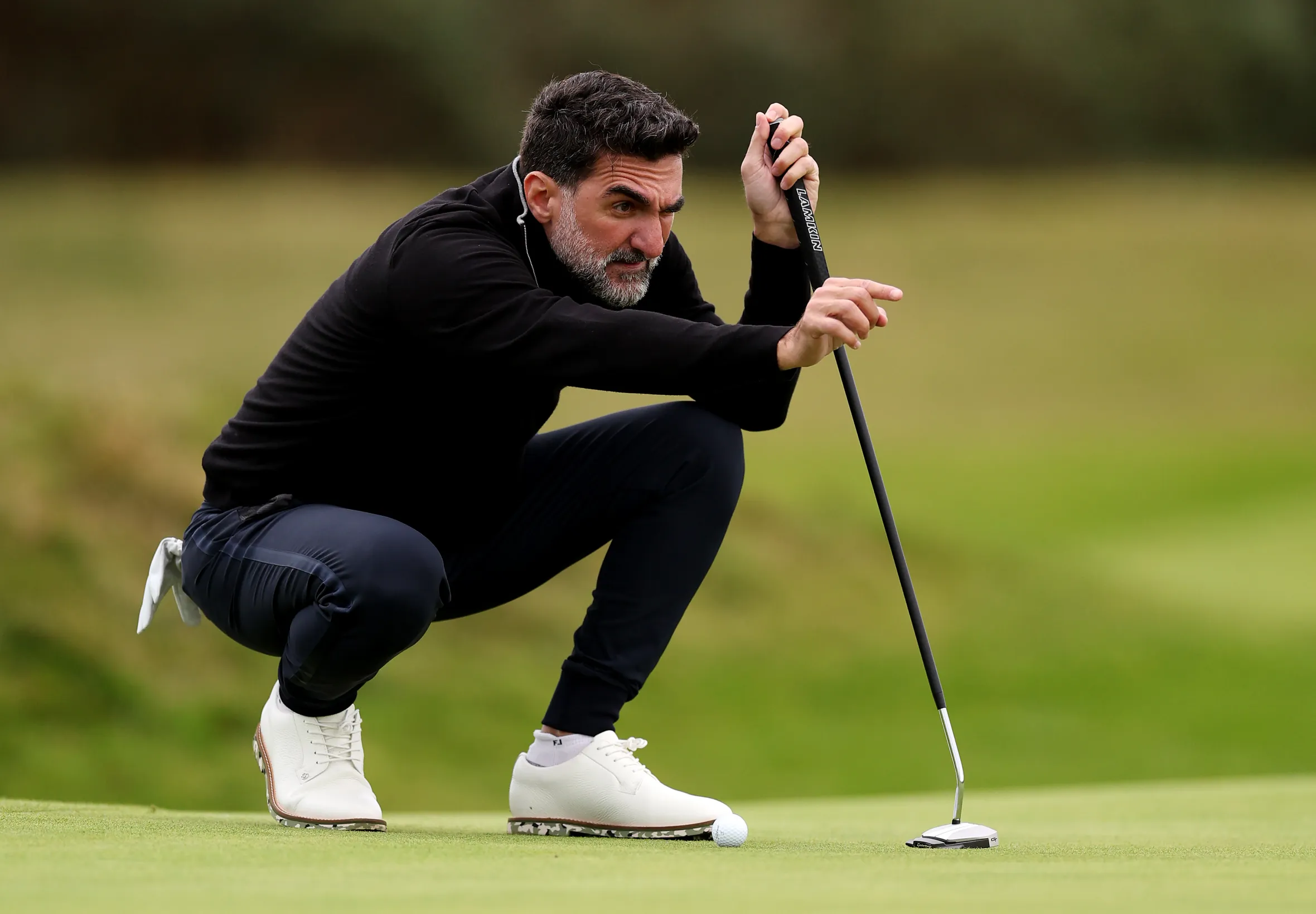 Yasir Al-Rumayyan lining up a putt on the 16th green.