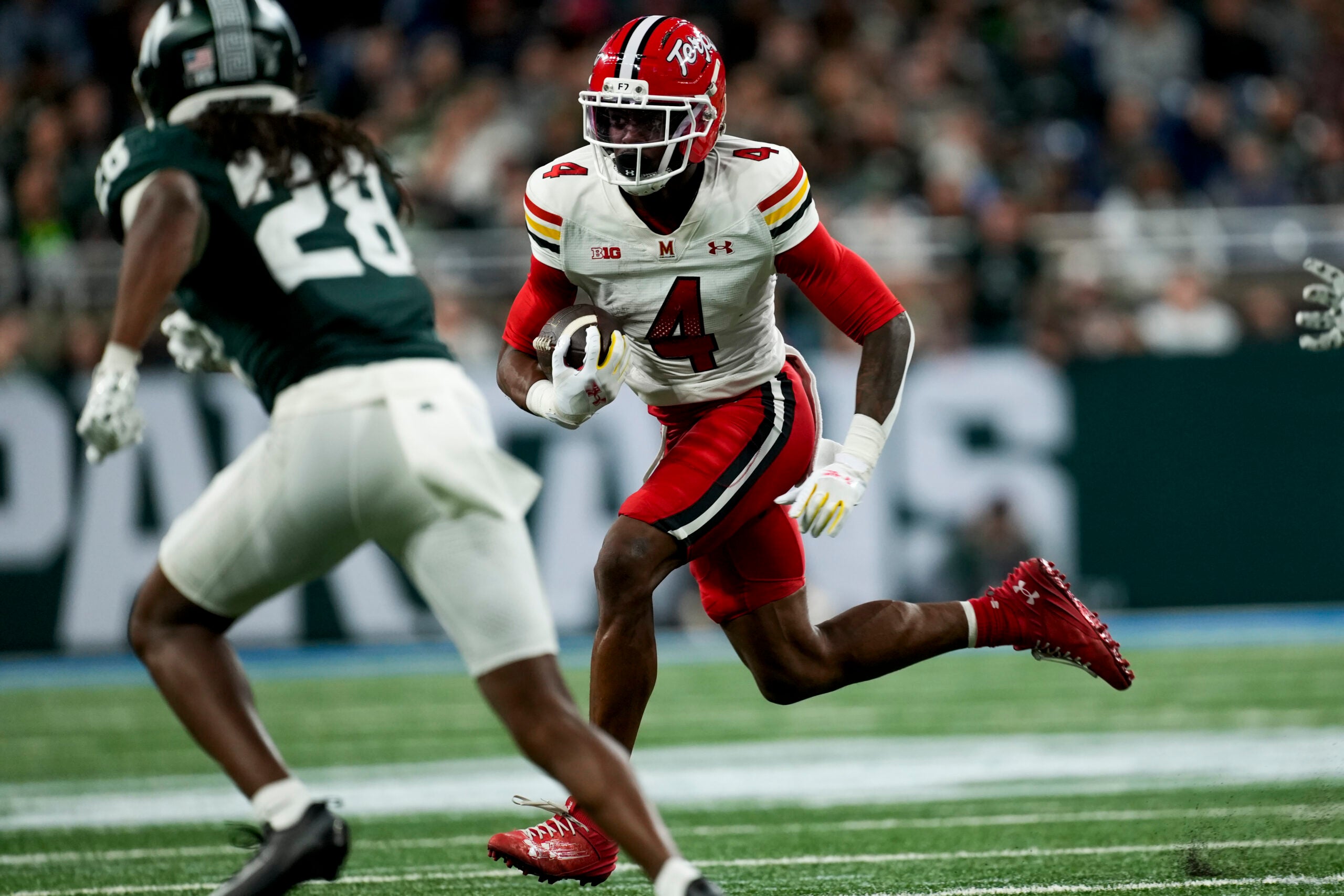 Nov 29, 2025; Detroit, Michigan, USA; Maryland wide receiver Shaleak Knotts (4) runs into Michigan State defensive back Dontavius Nash (28) in the second quarter at Ford Field.