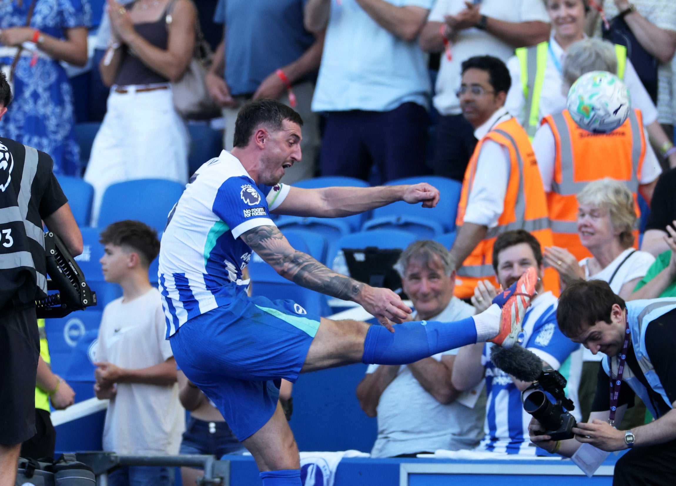 Lewis Dunk kicks a ball into the stands as he celebrates Brighton qualifying for the Conference League