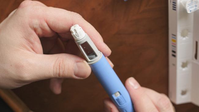 Person preparing a semaglutide injection pen.
