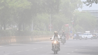Commuters make their way through a haze-filled road in Noida during a dust storm (Sunil Ghosh / Hindustan Times)