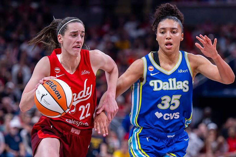 Indiana Fever guard Caitlin Clark (22) drives the ball past Dallas Wings guard Azzi Fudd (35) during the first half of an WNBA basketball in Indianapolis, Saturday, May 9, 2026. (AP Photo/Doug McSchooler)