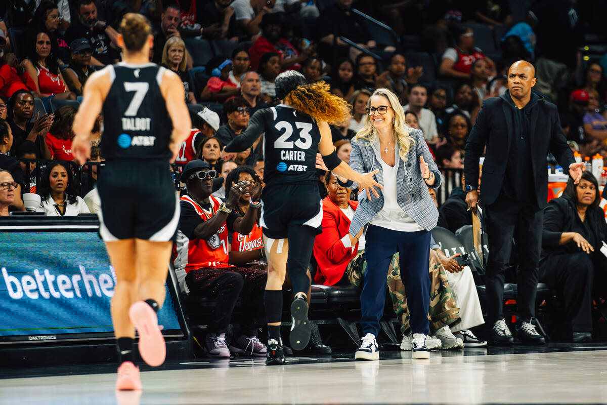 Aces head coach Becky Hammon high-fives Aces guard Chennedy Carter (23) as she heads back to th ...