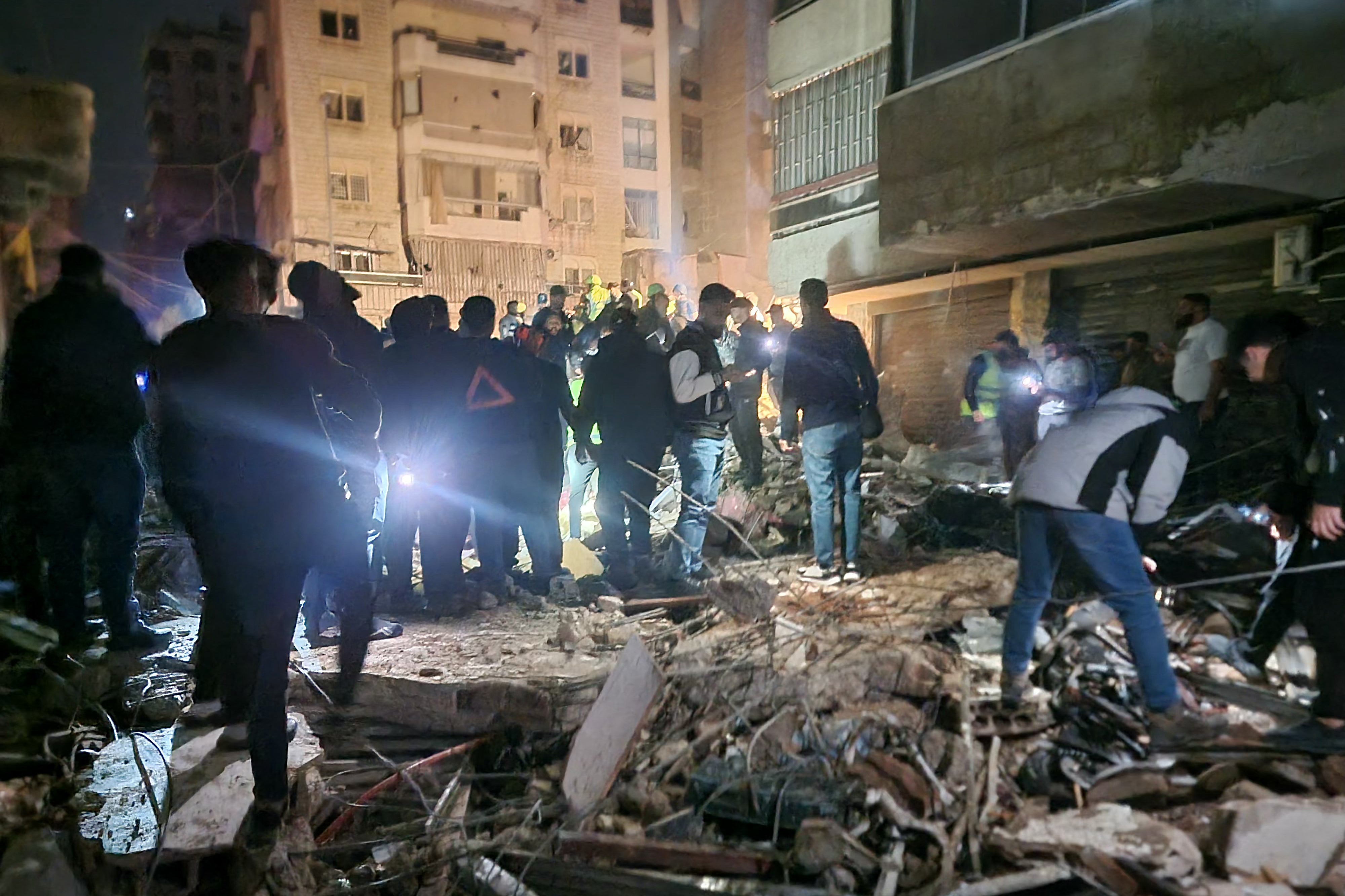 People gather at the site of an Israeli airstrike that targeted Beirut's southern suburbs neighbourhood of Haret Hreik