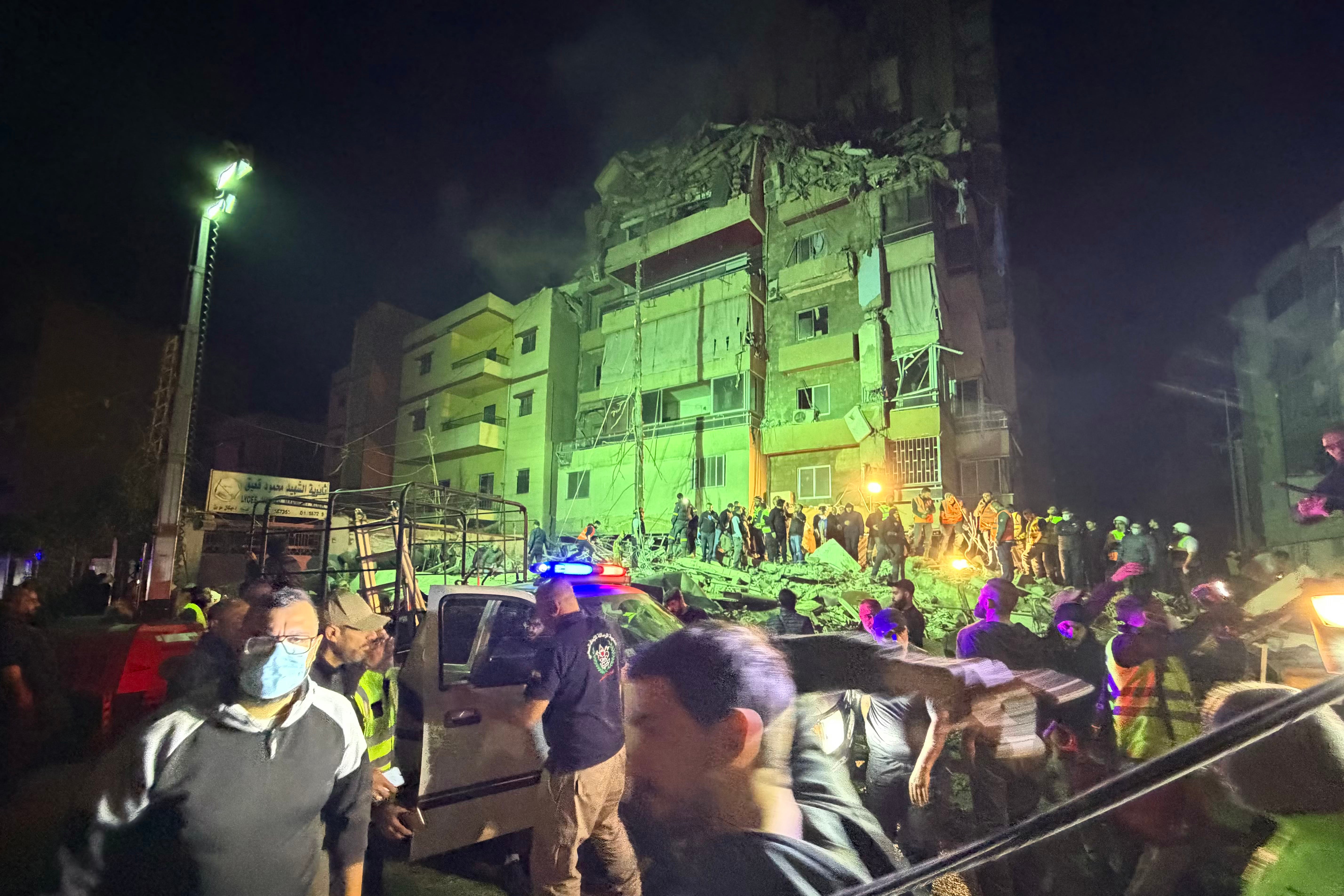 People gather at the site of an Israeli airstrike that targeted Beirut's southern suburbs Haret Hreik neighborhood