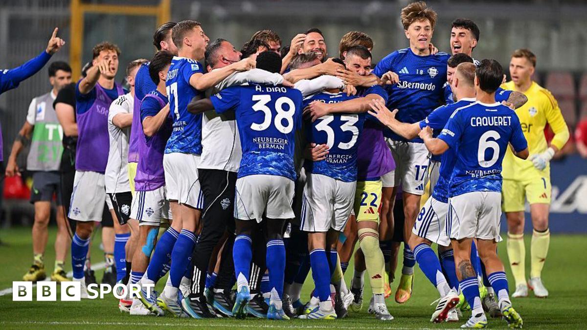 Como players, in blue shirts and socks and white shorts, celebrate in a huddle after securing Champions League qualification