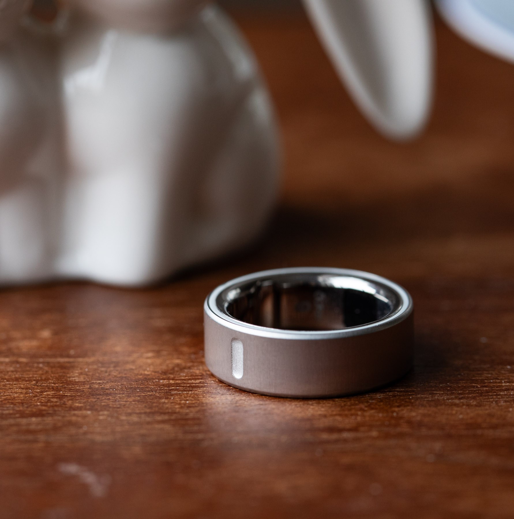 Close up of silver Oura Ring 4 on a wooden surface