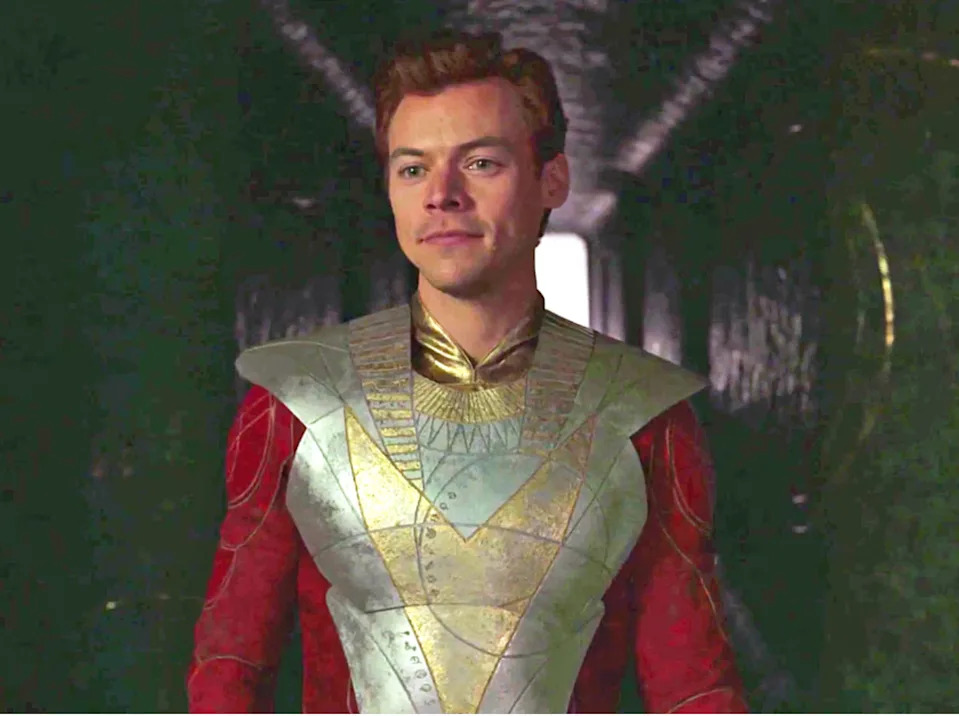 Person in futuristic metallic armor with intricate patterns, standing in a corridor