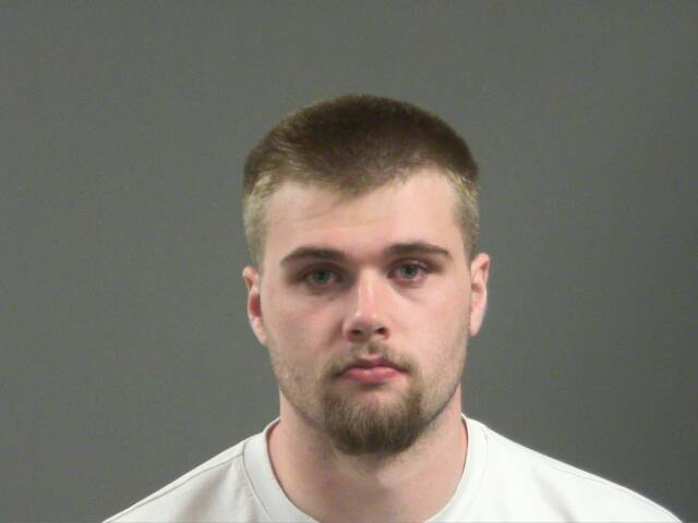 Mugshot of a man with a short beard and light-colored hair looking directly at the camera.