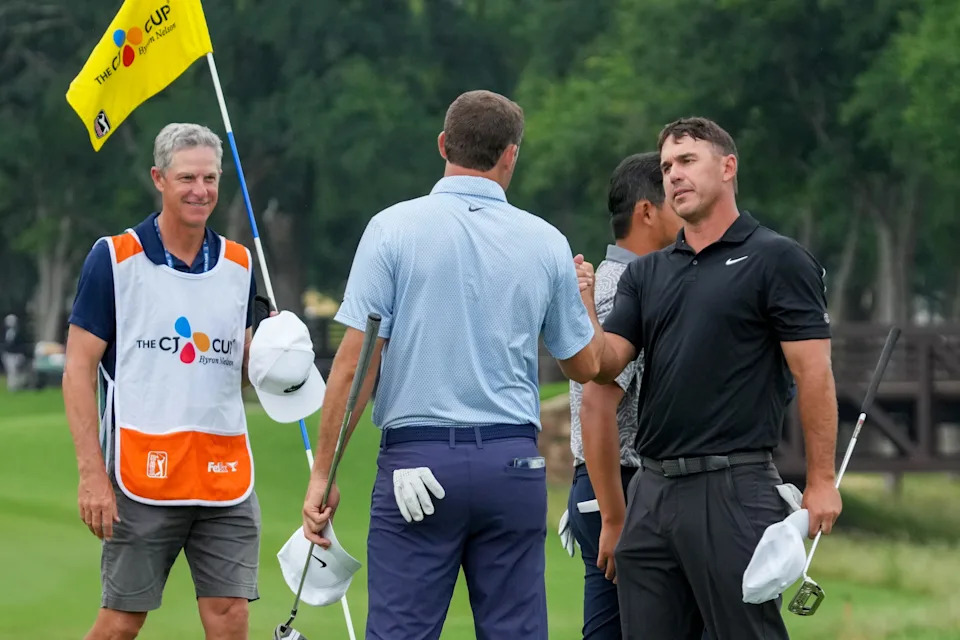 May 21, 2026; McKinney, Texas, USA; Brooks Koepka shakes hands with Scottie Scheffler following their round on the ninth green during the first round of THE CJ CUP Byron Nelson golf tournament. Mandatory Credit: Raymond Carlin III-Imagn Images