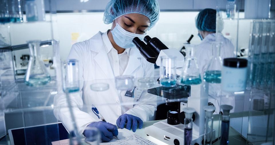 Researchers in protective equipment working in a pharmaceutical lab.
