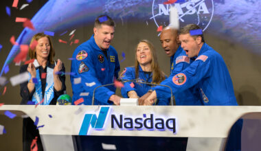 Nasdaq Chair and Chief Executive Officer Adena T. Friedman, left, and NASA’s Artemis II crewmembers CSA (Canadian Space Agency) astronaut Jeremy Hansen, and NASA astronauts Christina Koch, Victor Glover, and Reid Wiseman, right, ring the closing bell of the Nasdaq market session. They're standing behind a wide white podium with the Nasdaq logo and the word "Nasdaq." There is a screen on the front of the podium displaying the NASA meatball logo. Friedman is standing a little further away from the podium. Red, white, and blue confetti falls from the air on the left side of the image.