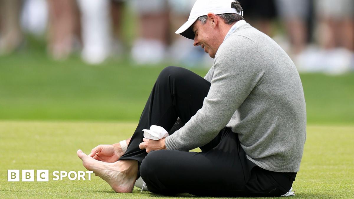 Rory McIlroy attending to his sore toe while on the third fairway at Aronimink Golf Club