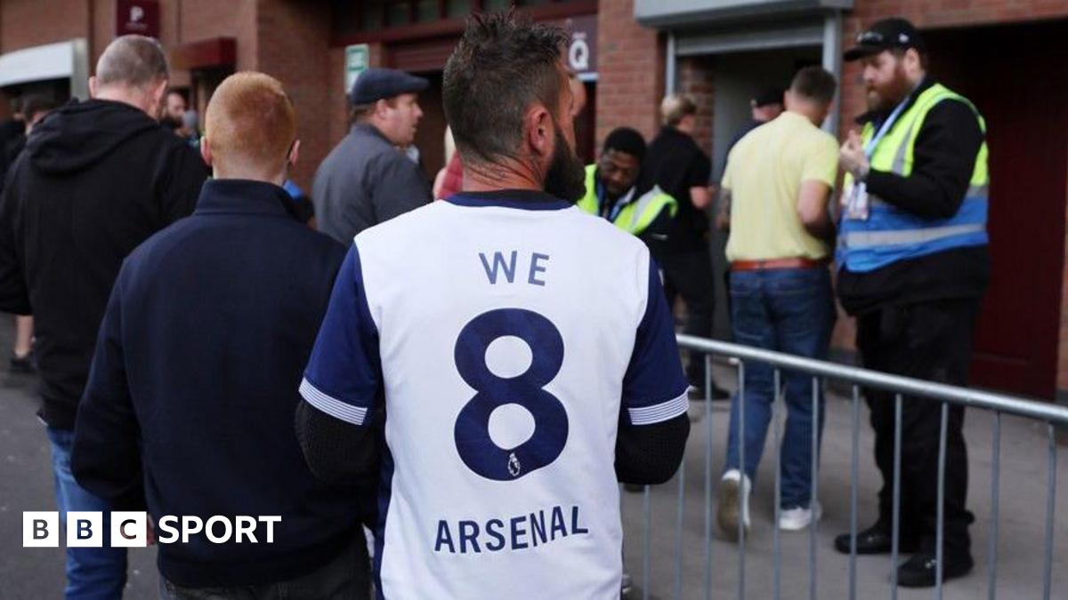 A Tottenham fan wearing shirt saying 'We 8 Arsenal'