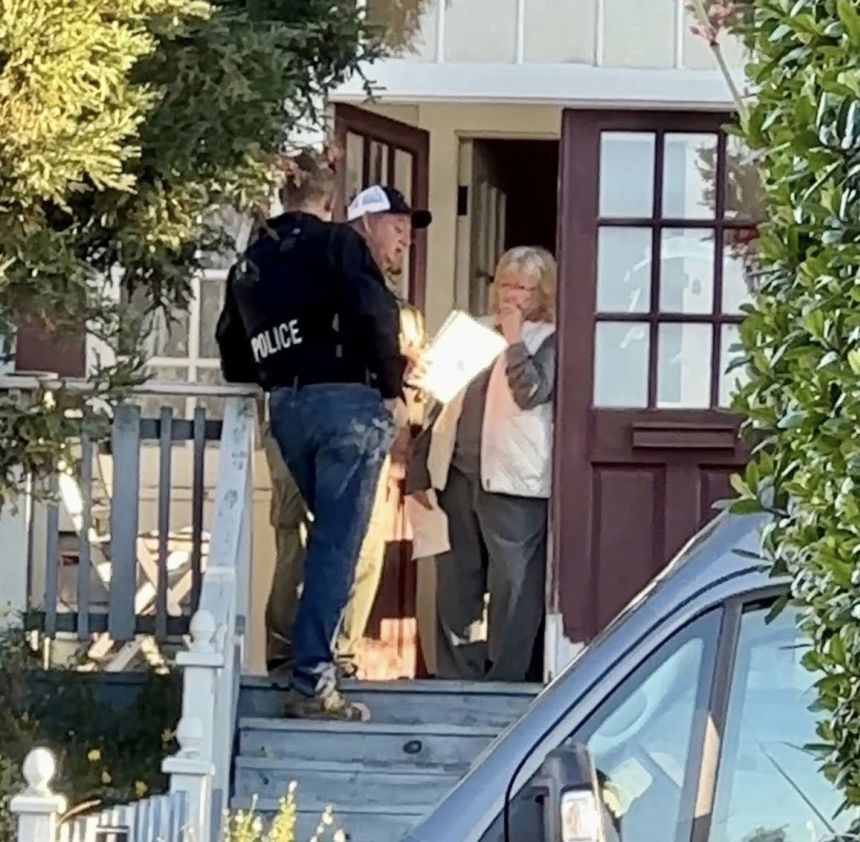 A photo shows Susan Flores, the mother of the man convicted for Kristin Smart's 1996 murder, receiving a search warrant for her house Wednesday morning. (<em>Chris Lambert/Your Own Backyard)</em>