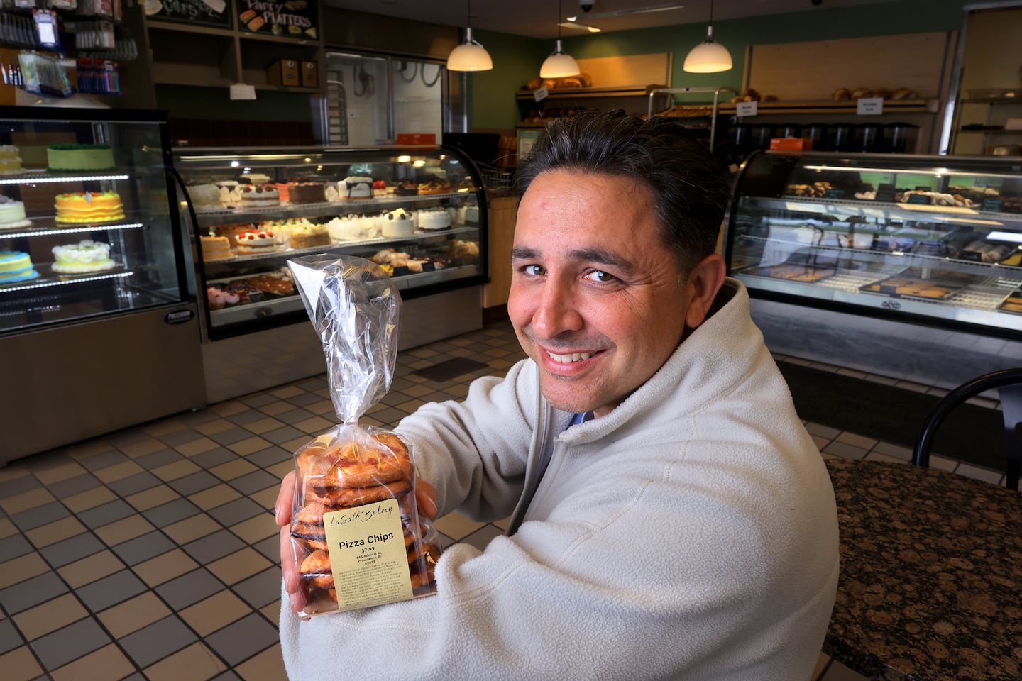 LaSalle Bakery owner Michael Manni Jr. shows off a bag of pizza chips.