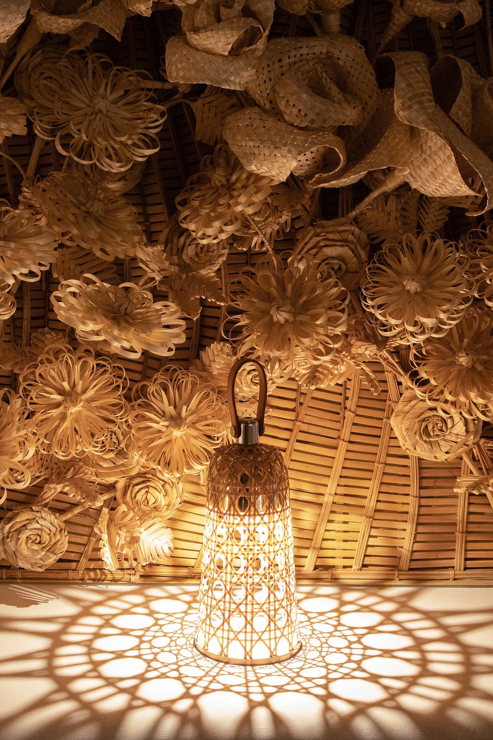 A woven lamp casting patterns on a surface.