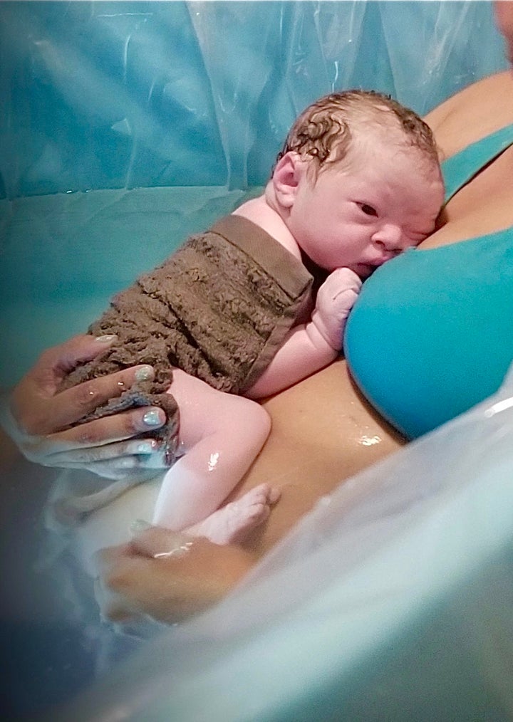 The author's oldest daughter in a birthing tub during her home water birth with her newborn son in 2018