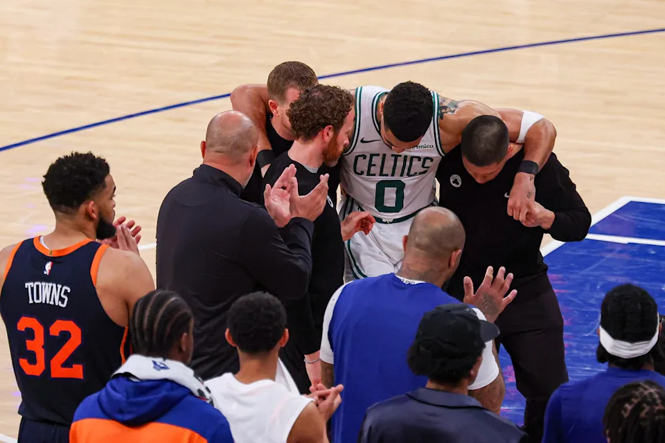 May 12, 2025; New York, New York, USA; Boston Celtics forward Jayson Tatum (0) is helped off the court by after an injury in the second half during game four of the second round for the 2025 NBA Playoffs against the New York Knicks at Madison Square Garden. Tatum would leave the game with an injury after this play. Mandatory Credit: Vincent Carchietta-Imagn Images
