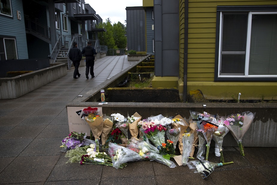 caption: Security guards walk near a growing memorial for the 19-year-old University of Washington student who was killed at Nordheim Court student housing in Seattle, on Wednesday, May 13, 2026.