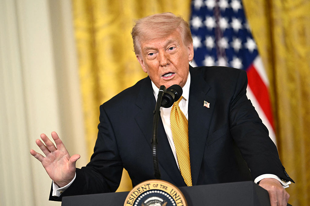 Donald Trump speaking at a podium.