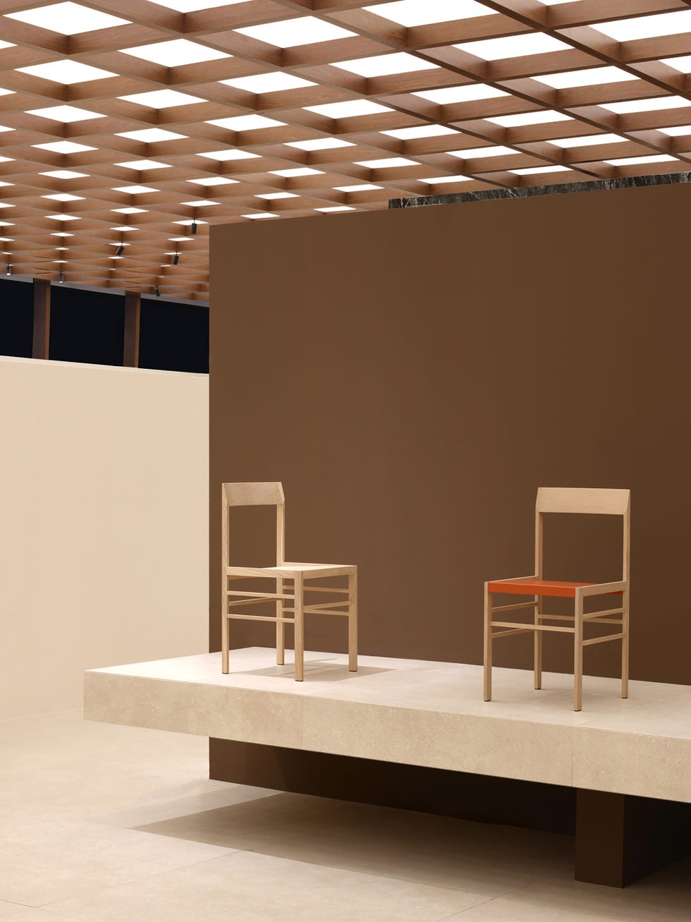 Two modern chairs on a minimalist platform in a spacious setting.