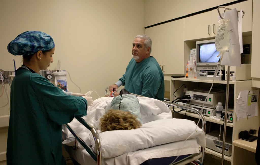 **ADVANCE FOR TUESDAY, OCT. 13** This Aug. 26, 2009 photo shows Dr. Pedro Jose Greer, right, preparing to do a colonoscopy at Mercy Hospital in Miami. Greer has made a career of offering treatment without regard to patients' ability to pay, and it's one reason he received a 2009 Presidential Medal of Freedom. (AP Photo/Lynne Sladky)