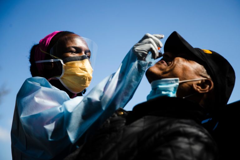 Dr. Ala Stanford administers a COVID-19 swab test on Wade Jeffries in the parking lot of Pinn Memorial Baptist Church in Philadelphia, Wednesday, April 22, 2020. Stanford and other doctors formed the Black Doctors COVID-19 Consortium to offer testing and help address heath disparities in the African American community. (AP Photo/Matt Rourke)
